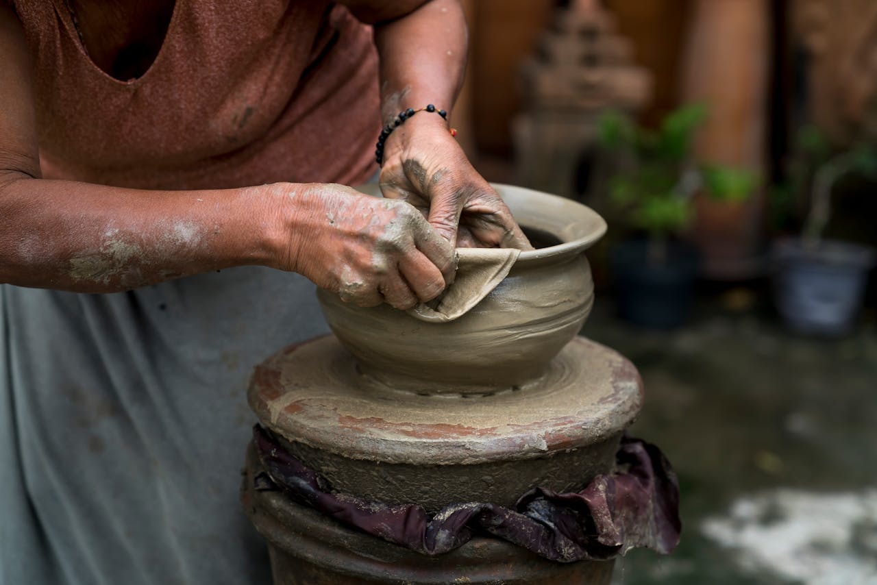 home-hero A skilled potter shaping clay on a wheel, showcasing traditional craftsmanship and creativity.